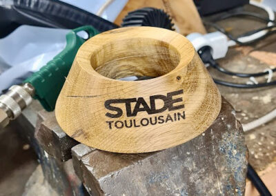 Un tee en bois avec le logo du Stade Toulousain