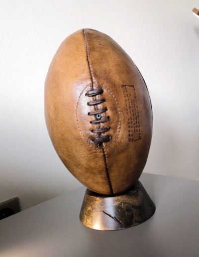 A vintage rugby ball on a wooden tee