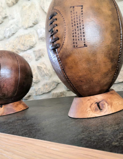 Comparison between a rugby ball and a football in the living room