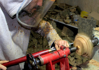 Tourneur sur bois en train de tourner un socle