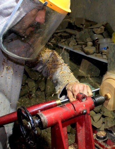 Tourneur sur bois en train de tourner un socle