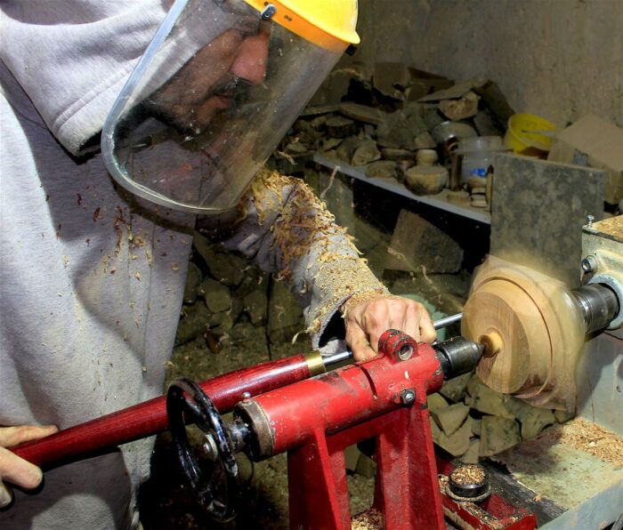 Tourneur sur bois en train de tourner un socle