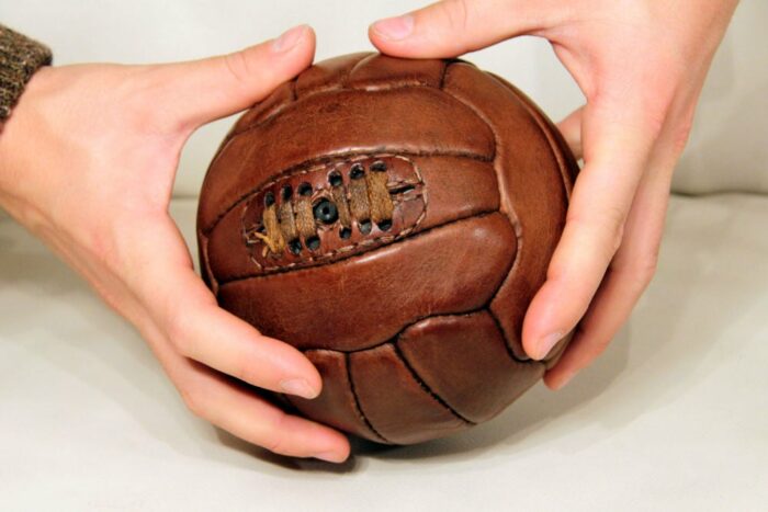 Mini ballon de foot tenu dans des mains d'un jeune homme