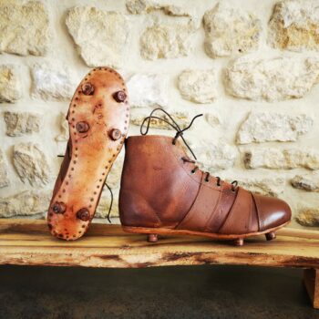 Paires de chaussures de foot ou rugby, vue de la semelle et du profil.