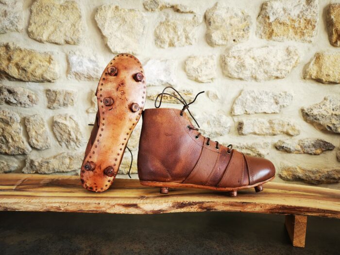 Paires de chaussures de foot ou rugby, vue de la semelle et du profil.