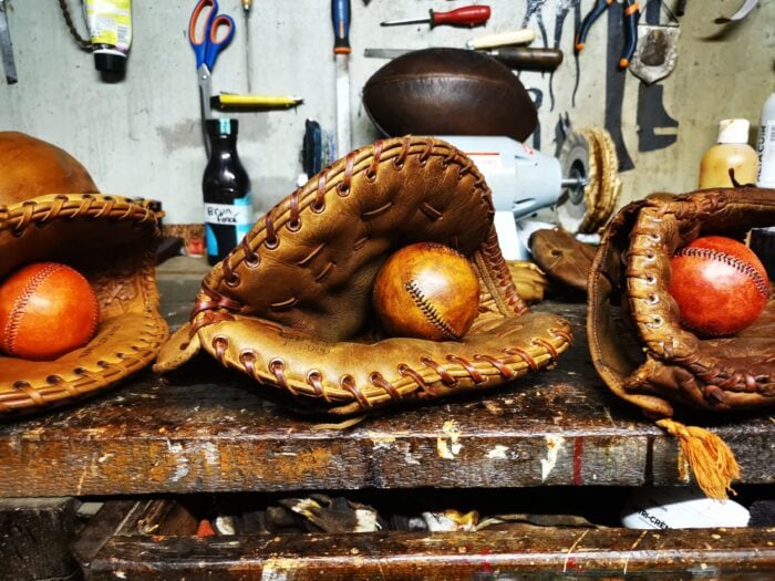 Des gants de baseball usagés posés sur un atelier.