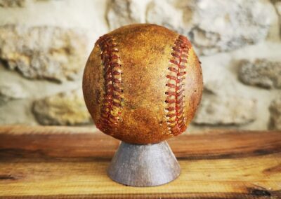 Vieille balle de baseball posée sur un socle en décoration.