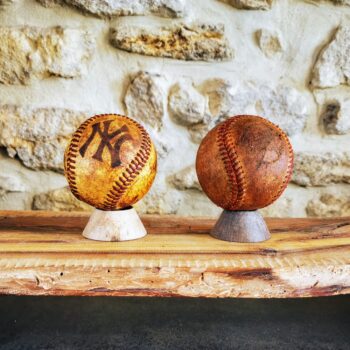 2 balles de baseball anciennes posées sur un socle en décoration