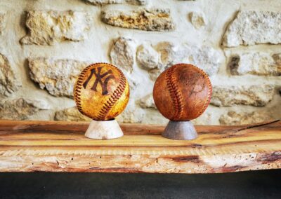 2 balles de baseball anciennes posées sur un socle en décoration