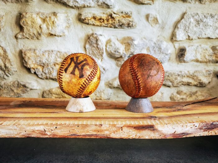 2 balles de baseball anciennes posées sur un socle en décoration