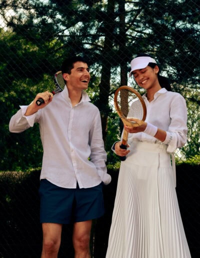 Une raquette de tennis Donnay vintage toute en bois dans les mains d'un couple qui jouent au tennis