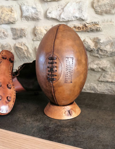 allon de rugby présenté avec des chaussures crampons