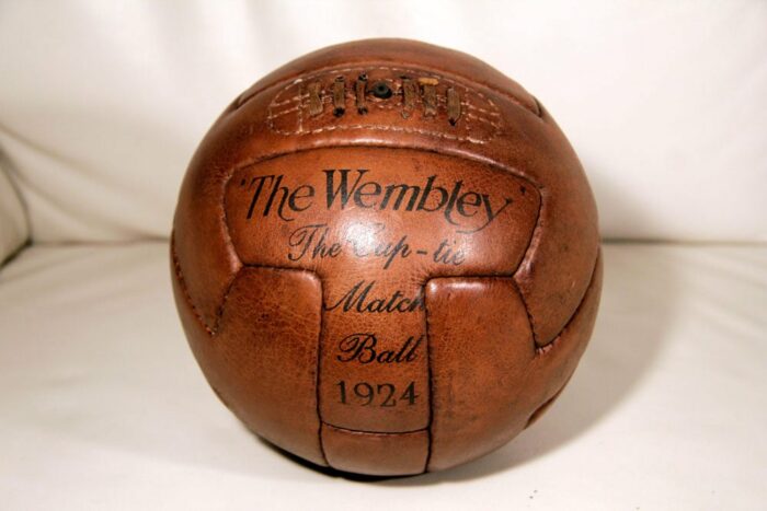 An old honey-coloured soccer ball on a leather sofa