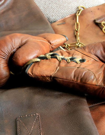 Une paire de gants de boxe ancienne présentées à lalumière sur du cuir