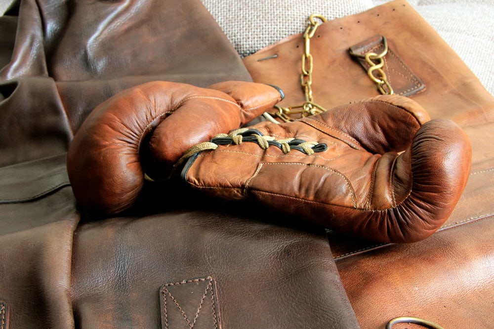 Une paire de gants de boxe ancienne présentées à lalumière sur du cuir