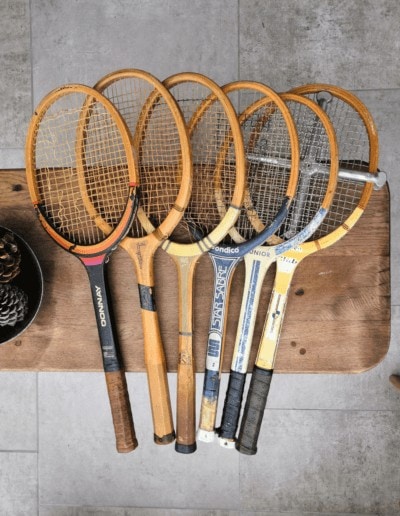 Des raquettes de tennis anciennes posées sur une table en bois