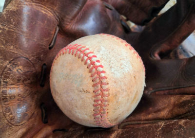 Une balle de baseball présentée dans un gants de baseball en cuir