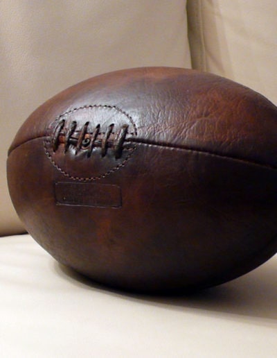 Leather rugby ball on a light-coloured sofa