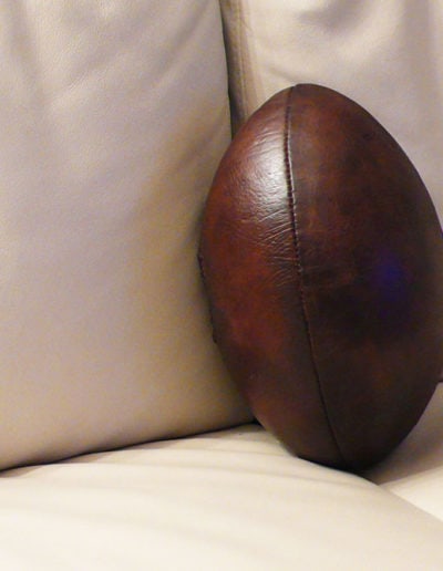 Brown leather rugby ball in the middle of the sofa