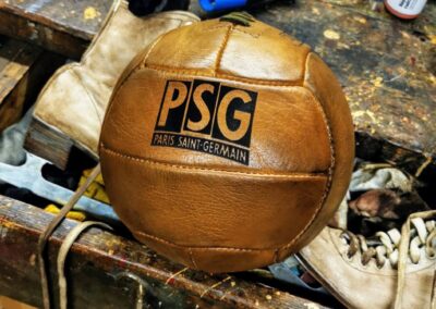 Un ballon de foot vintage du PSG avec le logo gravé sur le cuir aux cleurs miel