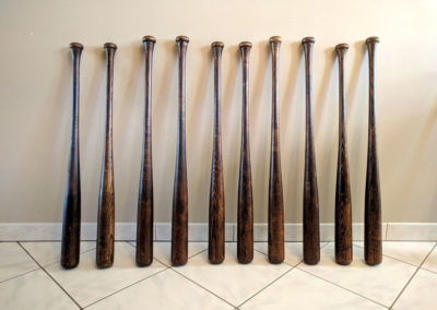 10 vintage baseball bats displayed next to each other.