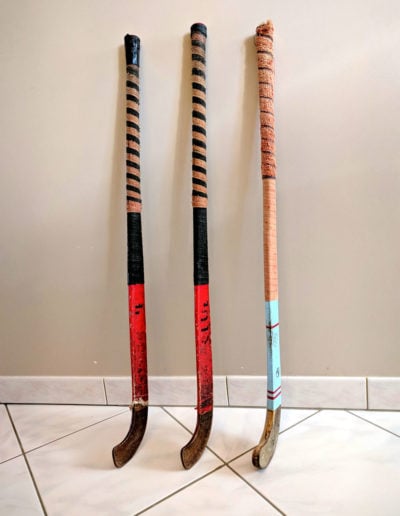 3 beautiful field hockey sticks presented in a kitchen