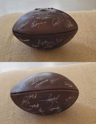 Un ballon de rugby vintage brun dédicacé par les membres du Lou Rugby