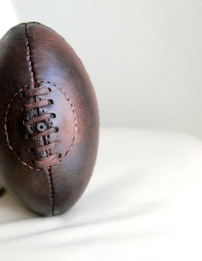 A ball sitting on his white leather sofa in the daylight