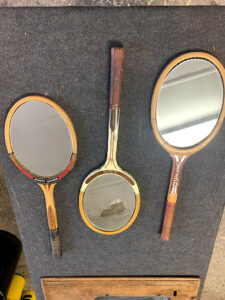 Des raquettes de tennis vintage en bois avec un miroir à l'intérieur.