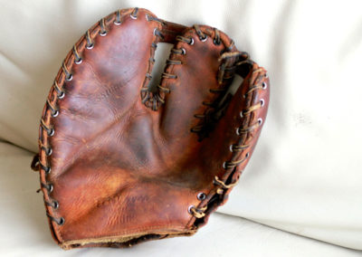 Gant de baseball avec du vieux cuir posé sur un canapé