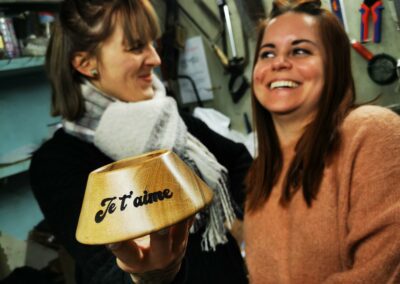 2 filles avec un socle tee de rugby en bois entre les mains avec écris Je t'aime