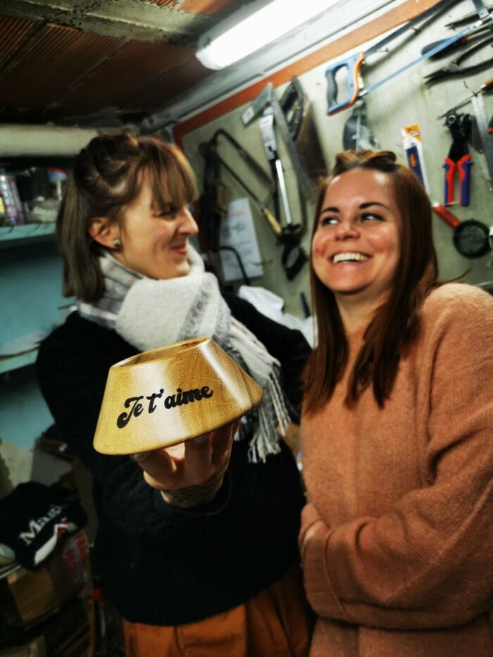 2 filles avec un socle tee de rugby en bois entre les mains avec écris Je t'aime