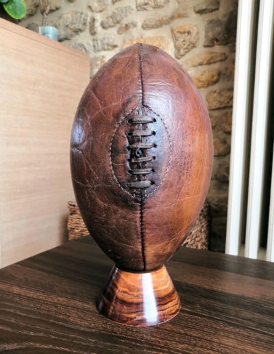 Un ballon de rugby posé sur un tee en bois