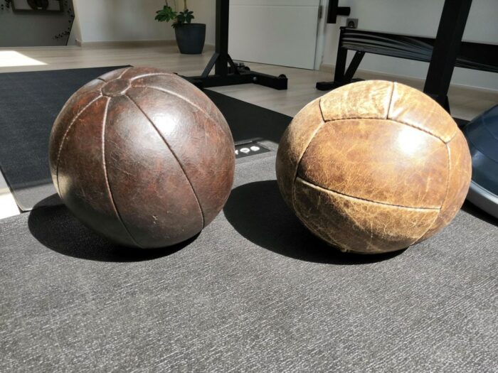 2 old leather medicine balls in a gym