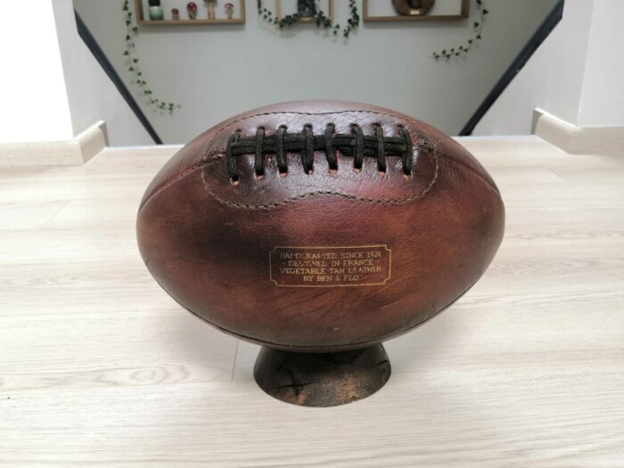 Ancien ballon de football américain posé sur un socle