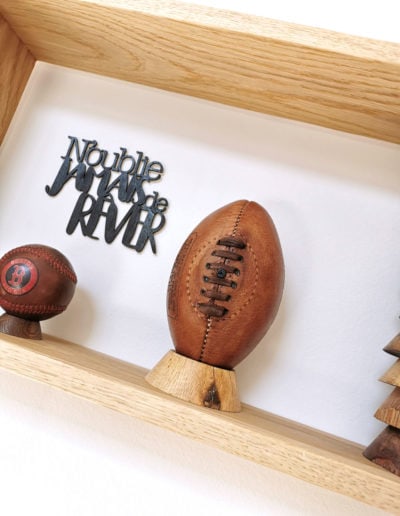 Un ballon de rugby vintage sur un socle en bois clair