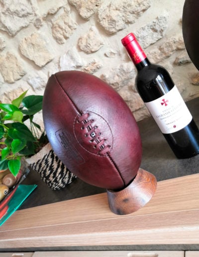 Old burgundy ball next to a bottle of wine