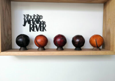 5 baseballs on a wooden shelf