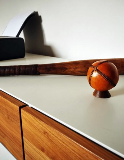 A single antique baseball on a piece of furniture