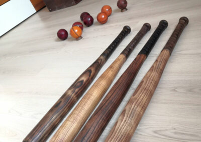 4 battes de baseball en bois ancien posées au sol