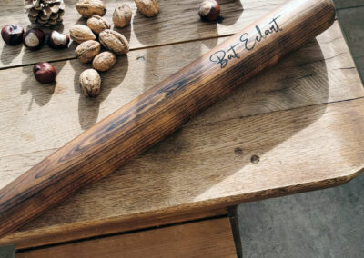 Batte de baseball bois personnalisable posée sur une table en bois