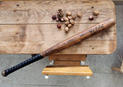 Batte de baseball en bois avec des noix et des marrons posés sur une table