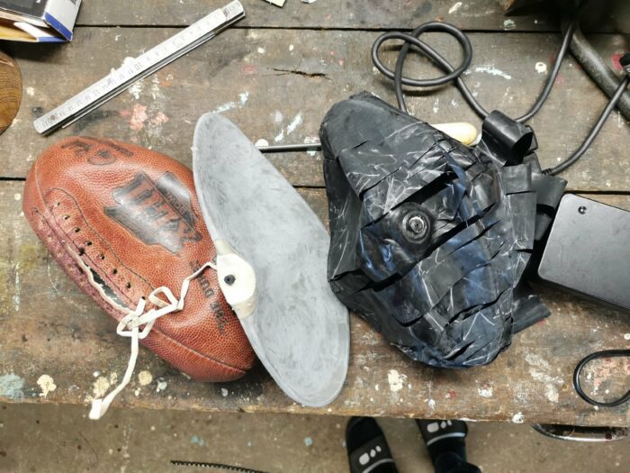 Un ballon de foot US avec 2 vessies posées sur un atelier