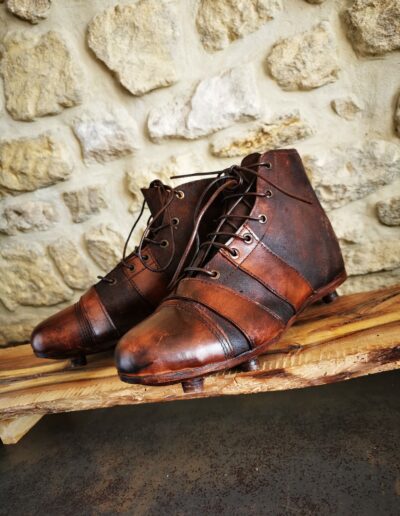 Paire de chaussures de foot ou rugby style ancien brun foncé.