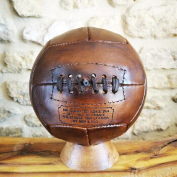 Ballon de foot vintage posé sur son socle en bois