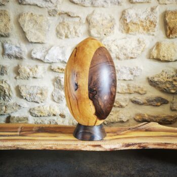 Ballon de rugby en bois posé sur un socle en décoration