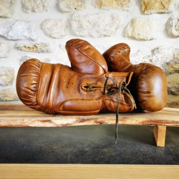 Une paire de gants de boxe en cuir posée sur un meuble