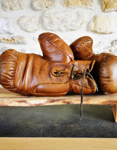 Une paire de gants de boxe en cuir posée sur un meuble