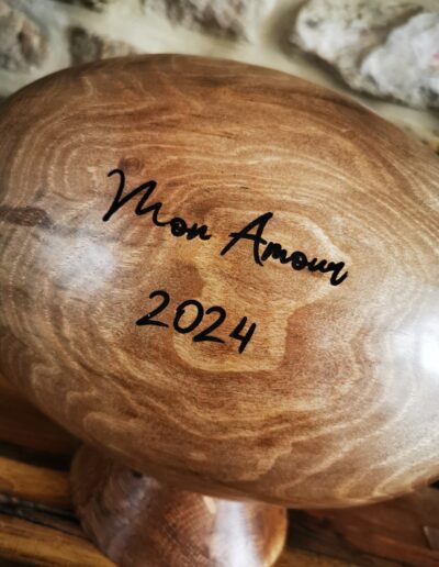 Un ballon de rugby en bois avec une gravure "Mon Amour 2024"