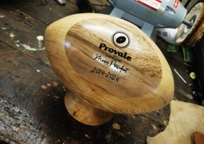 Un ballon de rugby en bois personnalisé gravé dans un atelier